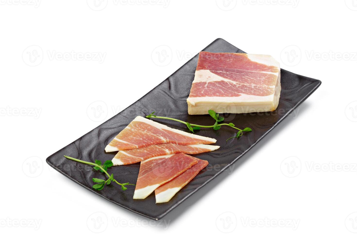 Sliced bacon lard on a plate isolated on white photo