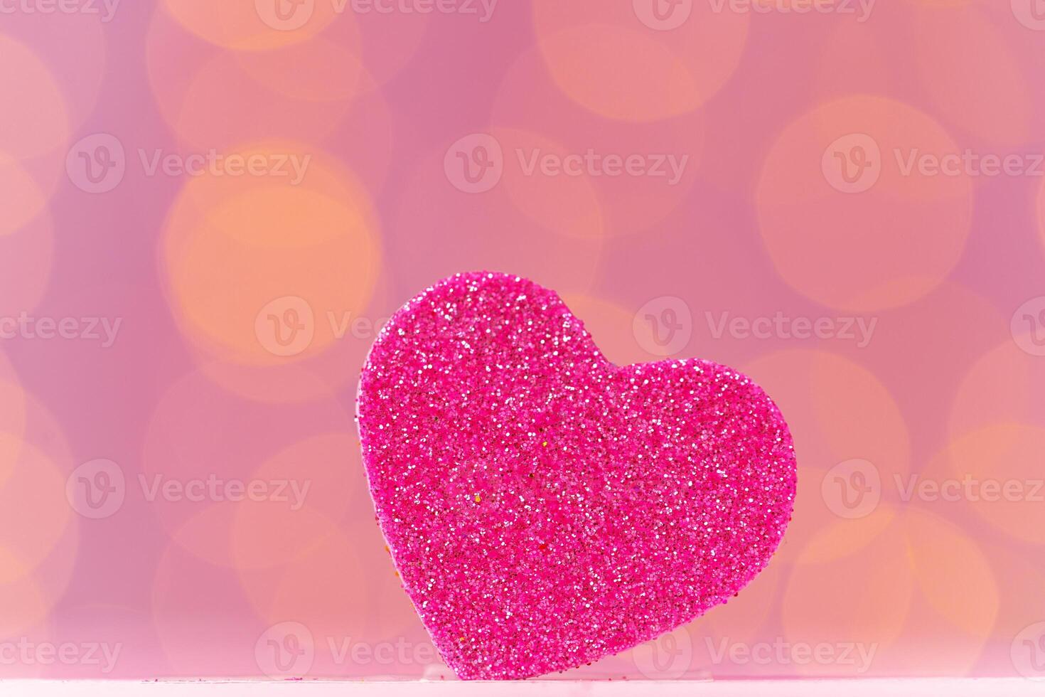 Pink glitter heart decoration on pink background photo