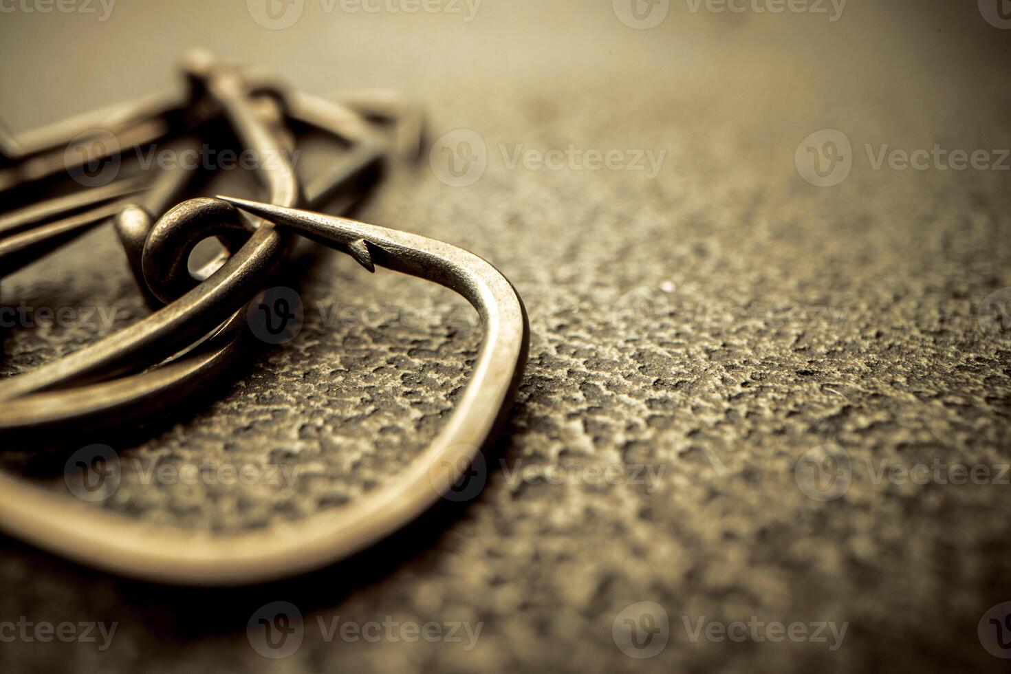 Fishing hooks on concrete textured background macro photo