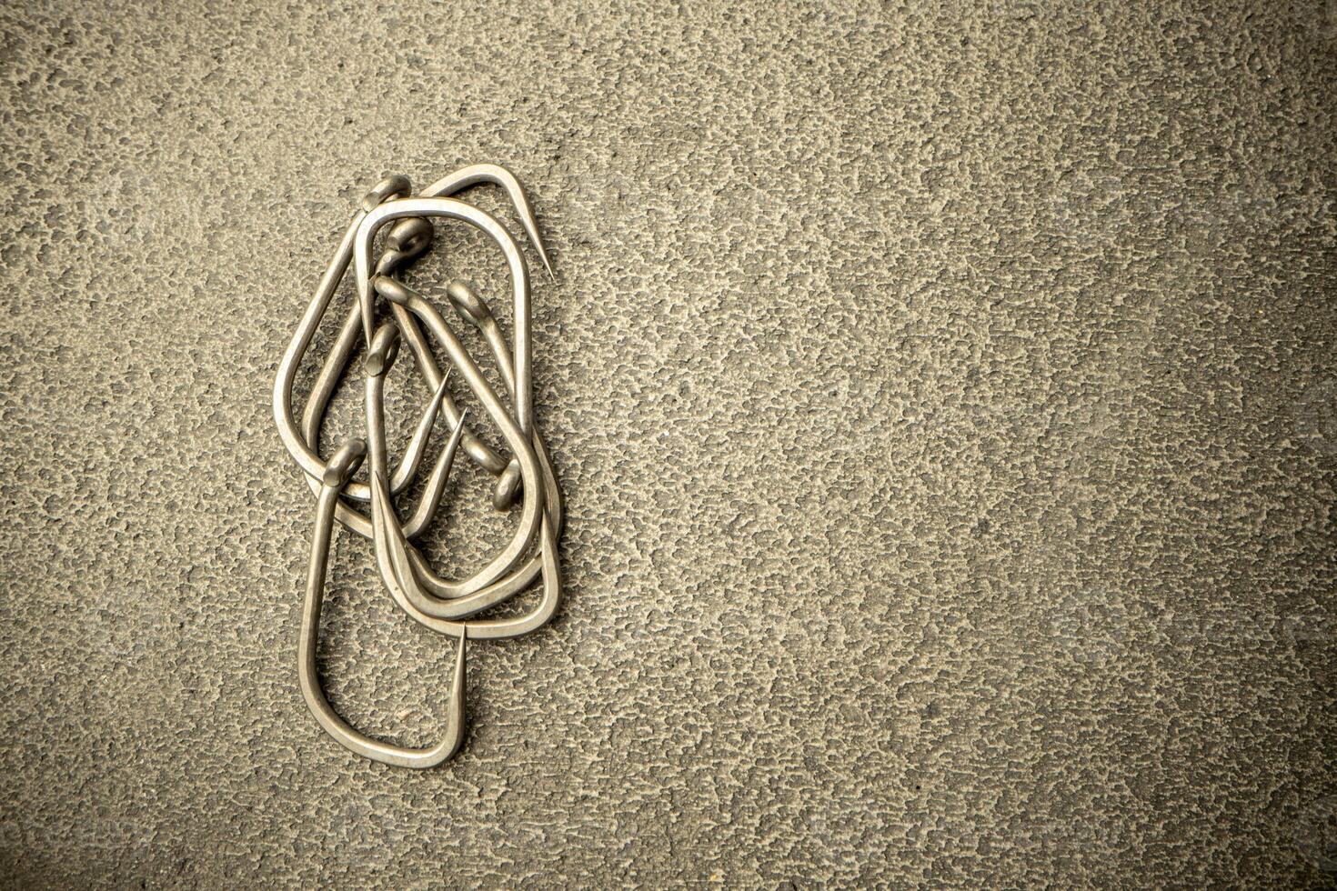 Fishing hooks on concrete textured background macro photo