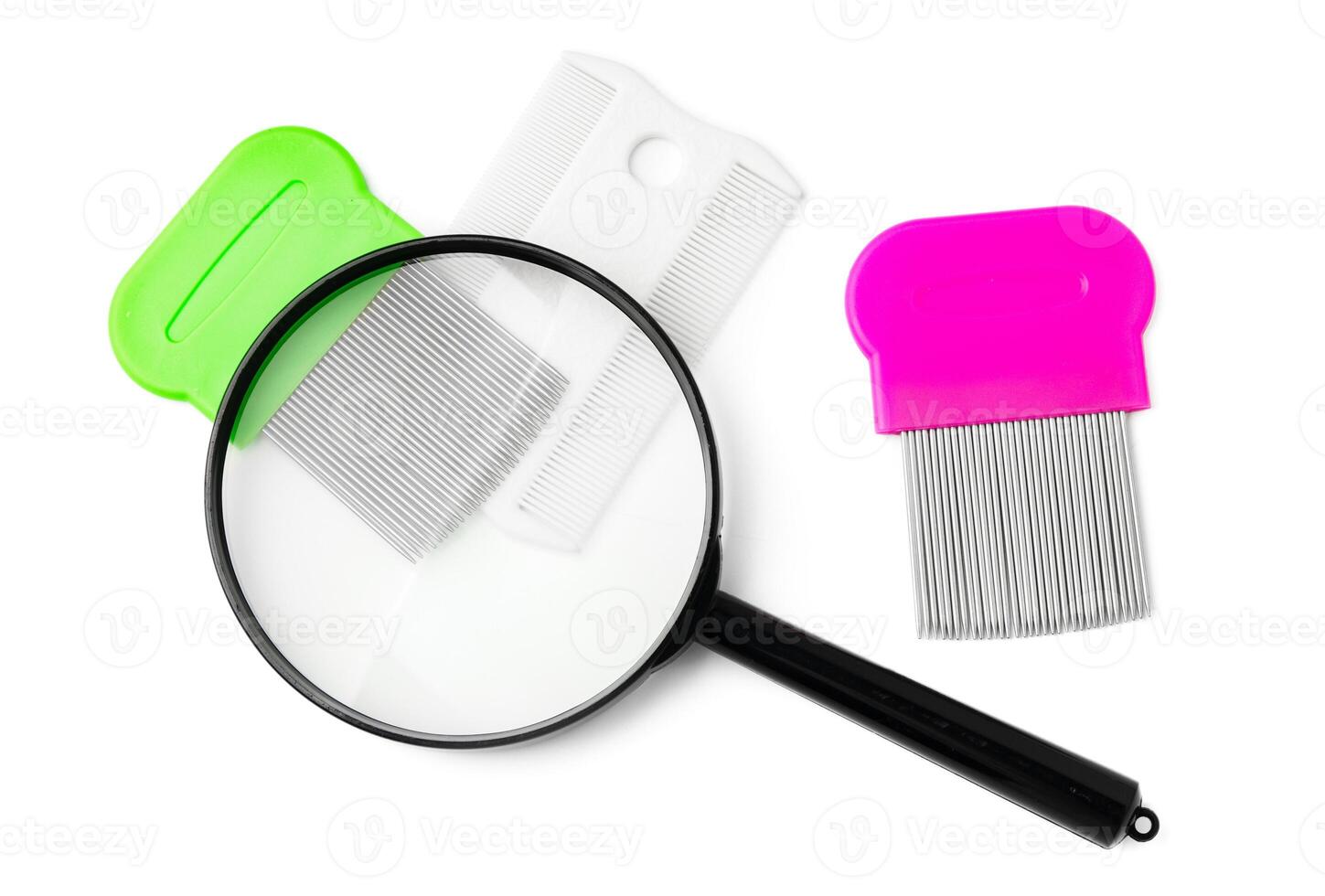 A magnifying glass and lice comb placed side by side on a clean white background photo