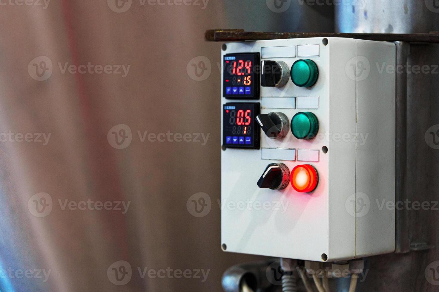 A control panel with two digital displays shows the temperature and pressure in a factory photo