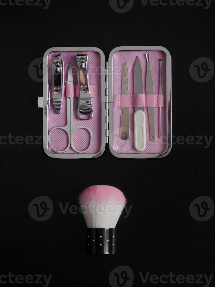 Pink manicure set isolated on black background with copy space photo