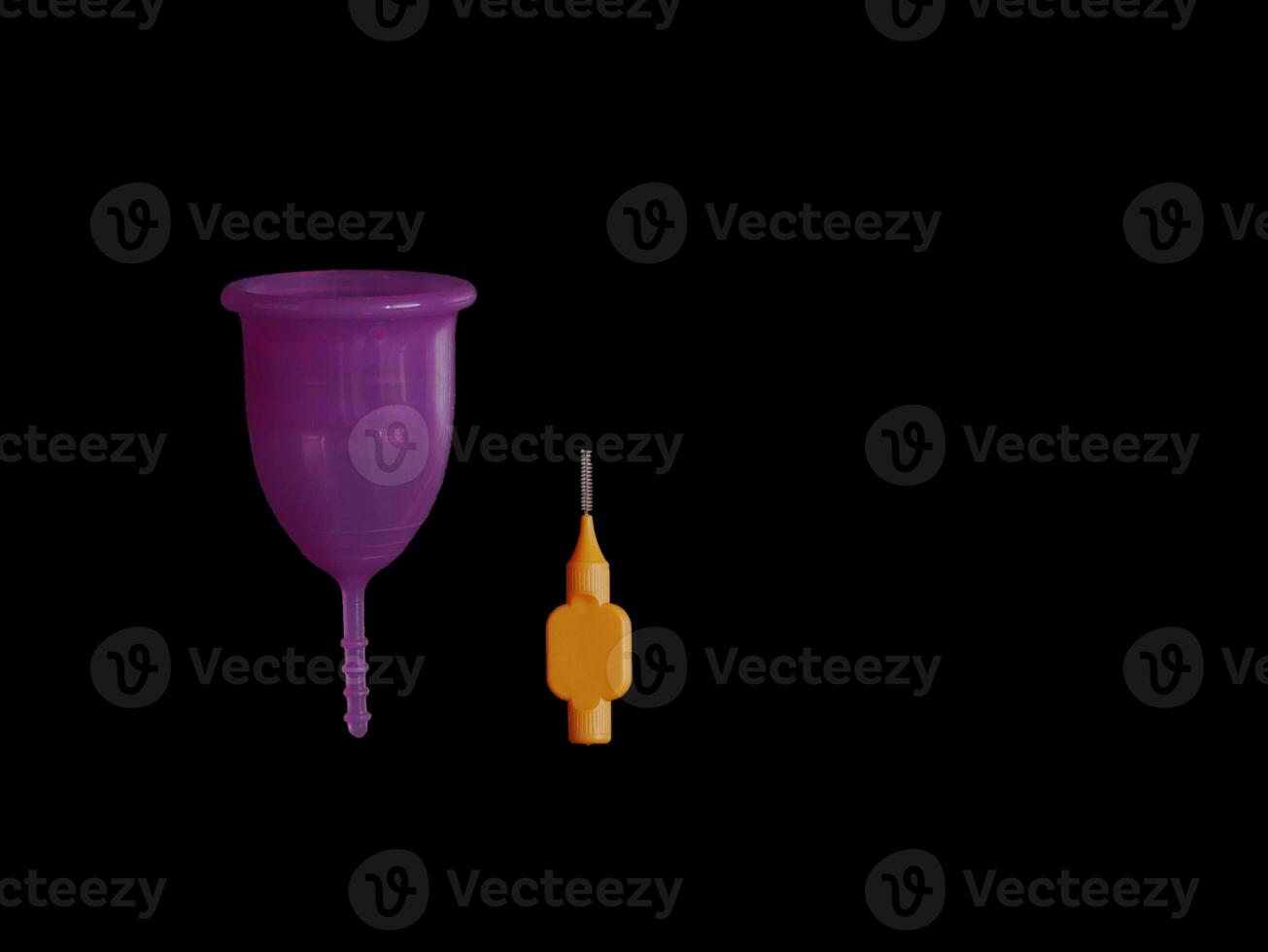 Menstrual cup with a special cleaning brush isolated on black background with copy space photo