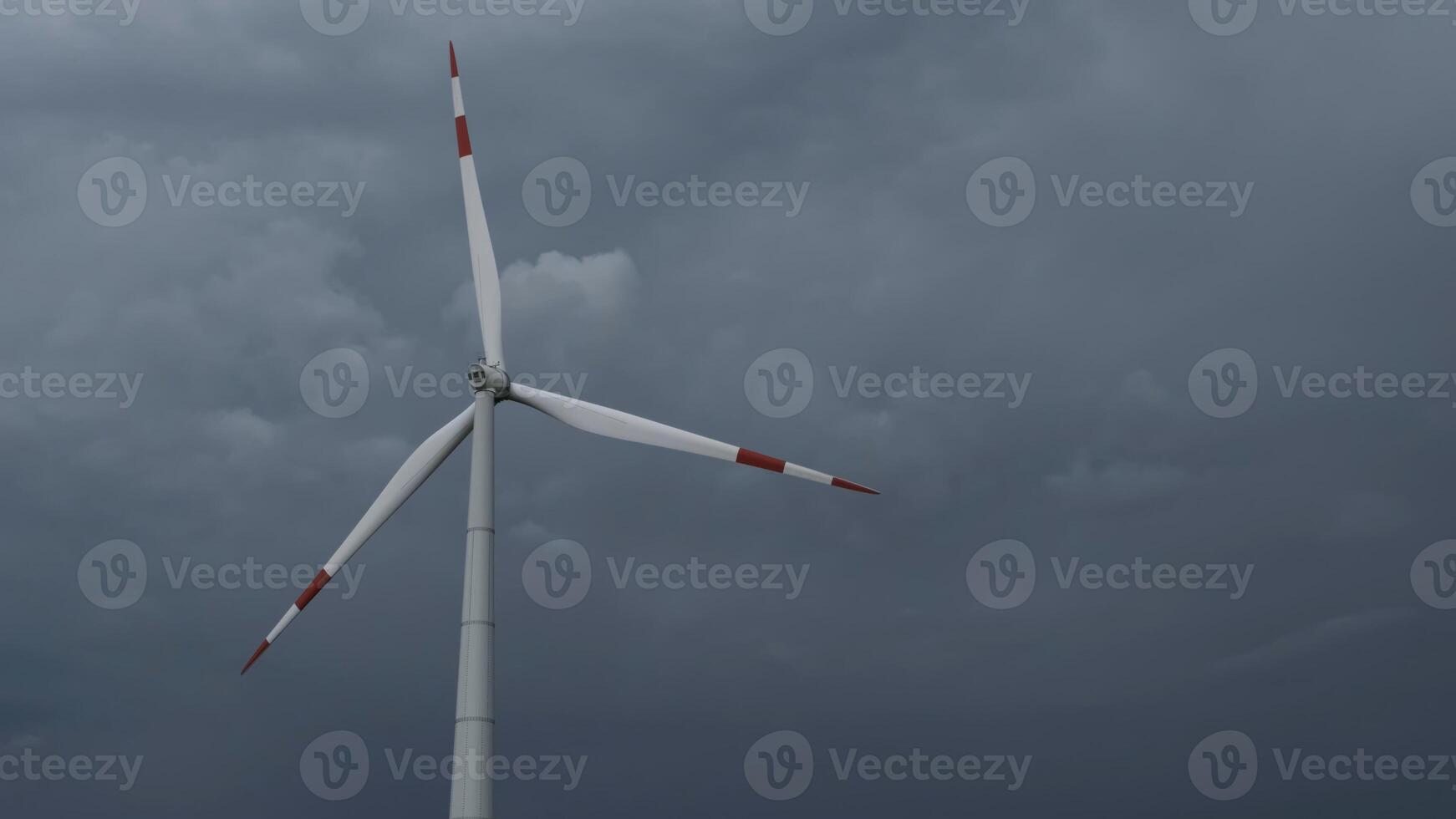 Windmill or wind turbine on wind farm in rotation photo