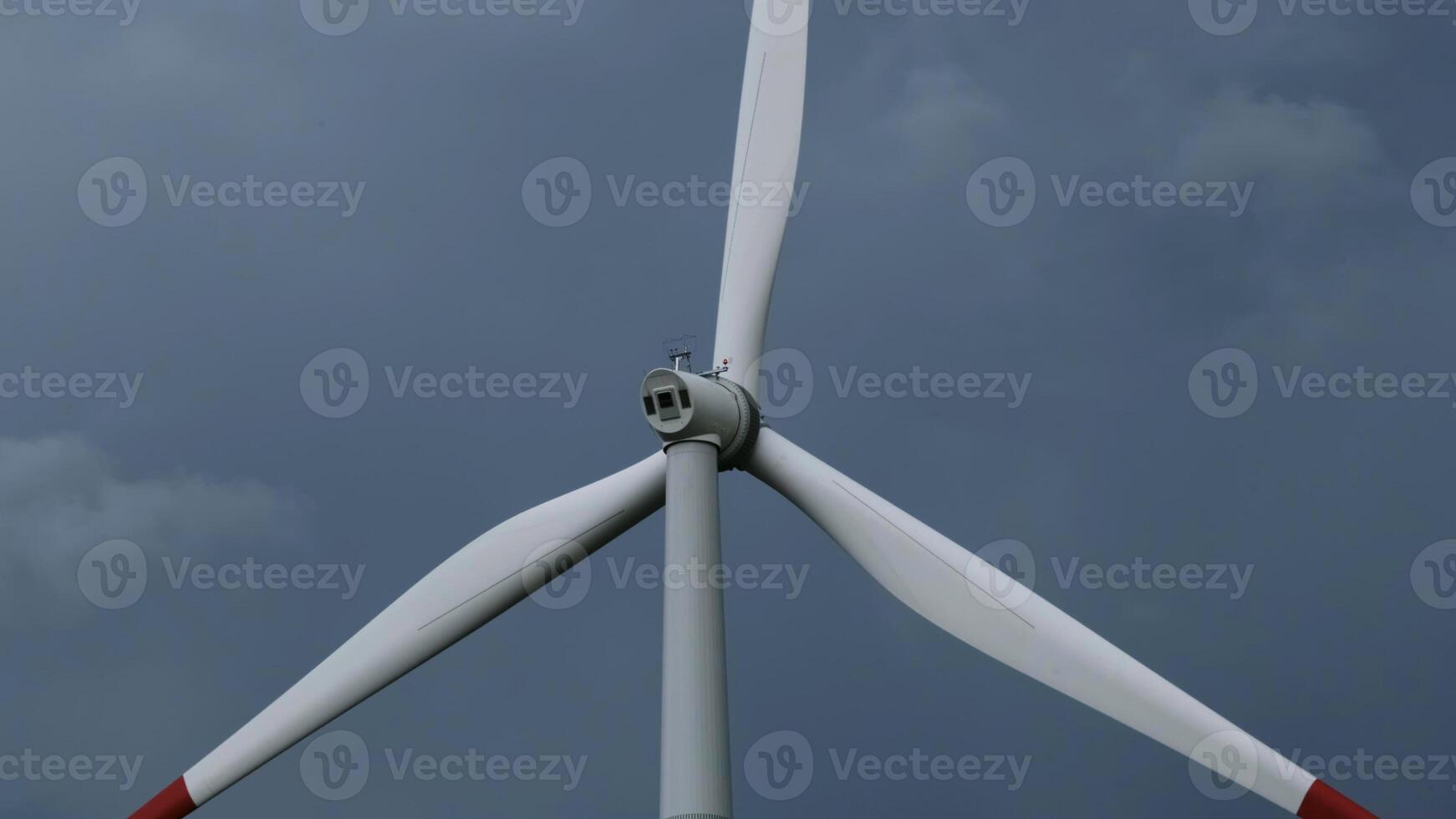 Windmill or wind turbine on wind farm in rotation photo