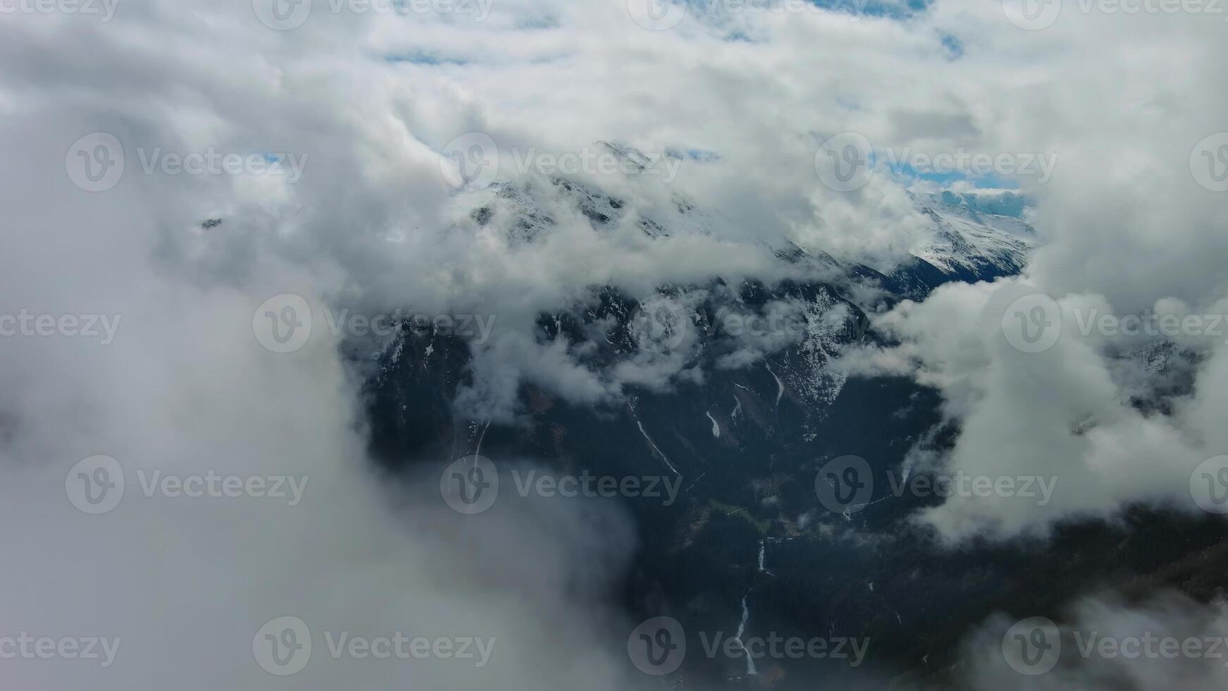 Aerial view of snowcapped mountains in clouds photo