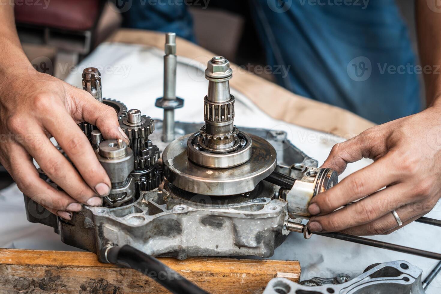 Motorcycle Engine Rebuild,Close up view of Motorcycle mechanic repairing gearbox,working at garage, maintenance and repair motorcycle concept photo