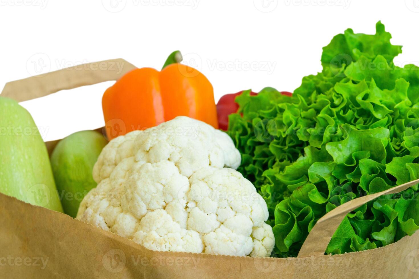Fresh food vegetables donation isolated on background in paper bag package. Healthy food delivery during coronavirus. photo