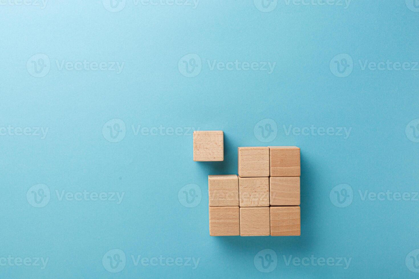 wooden cubes in a square of nine pieces in a row on a blue background photo