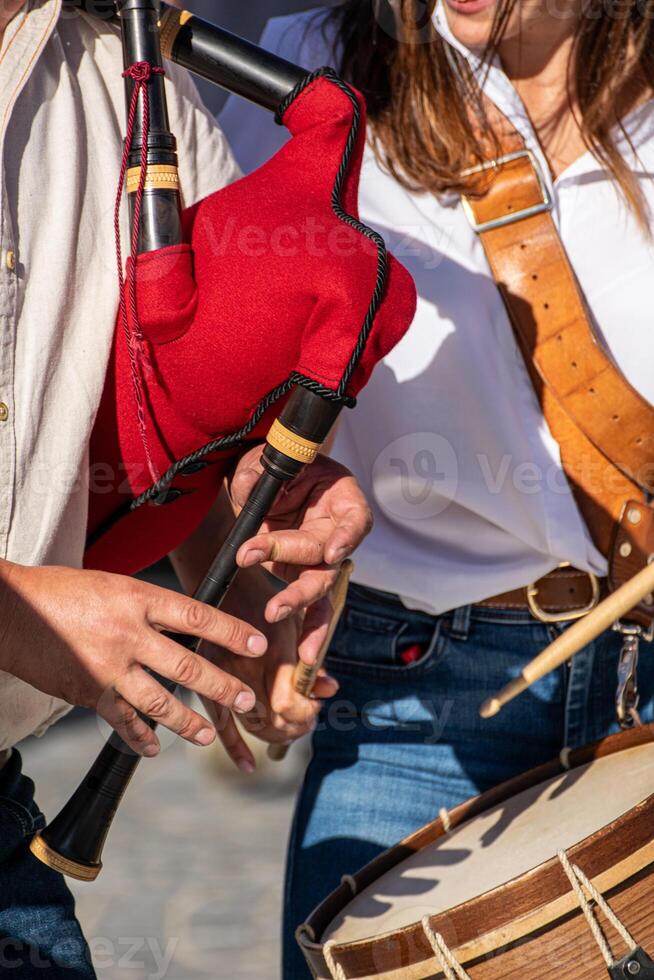 hands of a bagpipe player playing a traditional red bagpipe from Portugal, background concept folk music photo