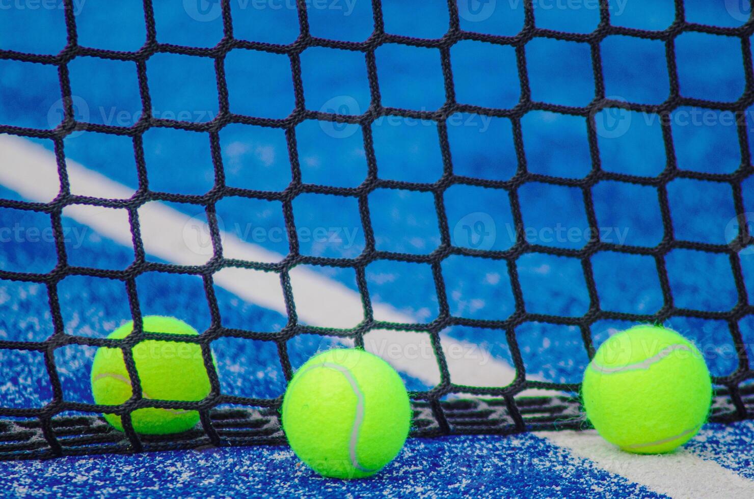 three balls near the net i na a paddle tennis court, background for racket sports photo