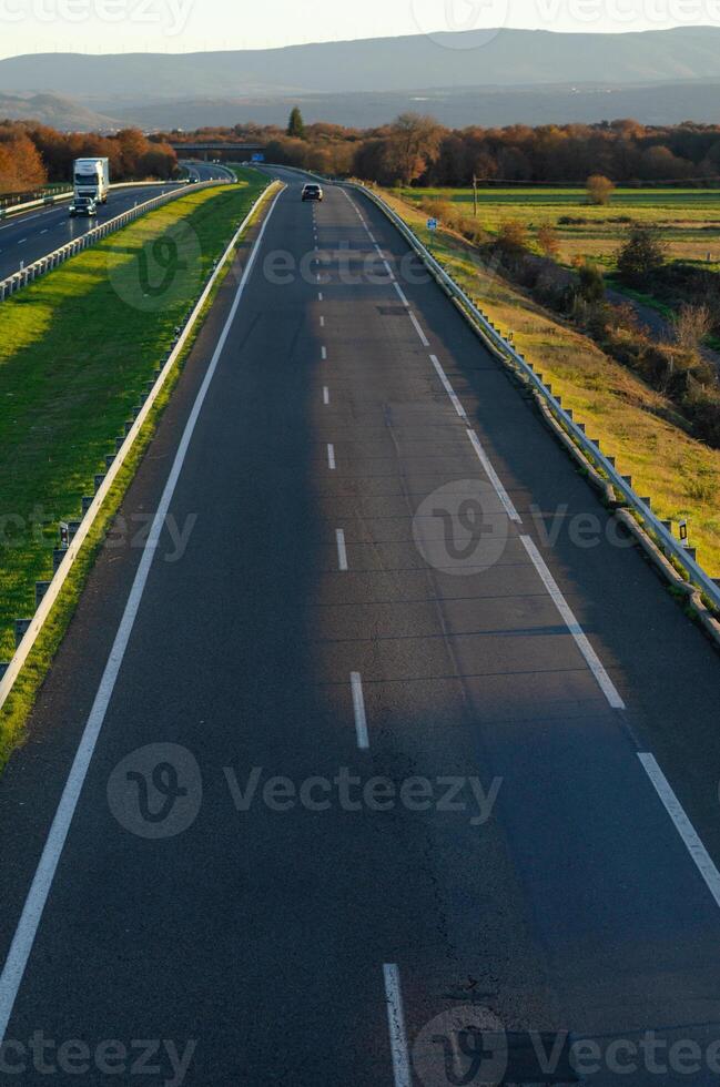 view of a lightly trafficked highway at dusk, background for transport concept photo