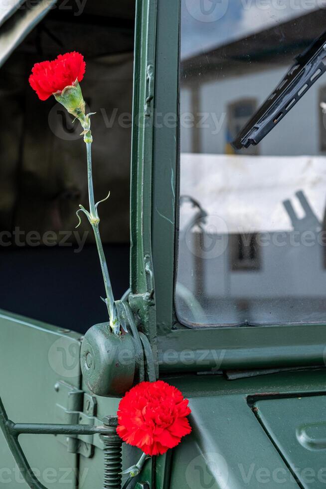 two red carnations decorating a military vehicle during the commemoration of April 25th in Portugal. Revolucao dos Cravos. photo