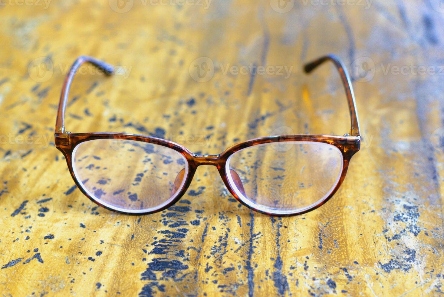 eyeglasses on a wooden table photo