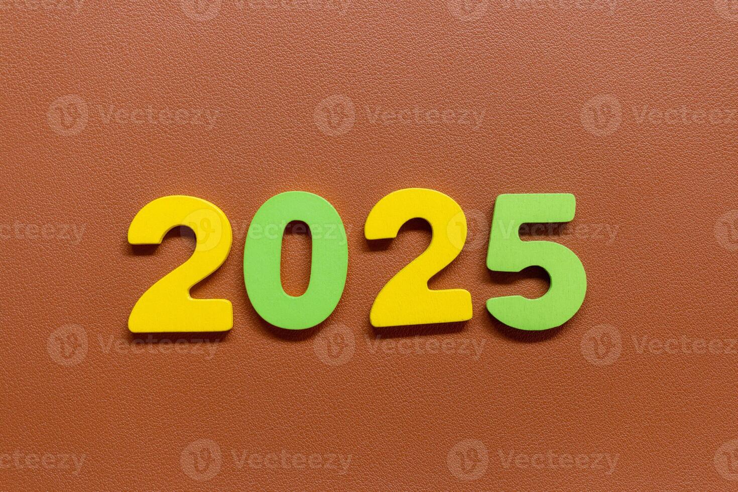 Colorful numbers 2025 on a brown textured background photo