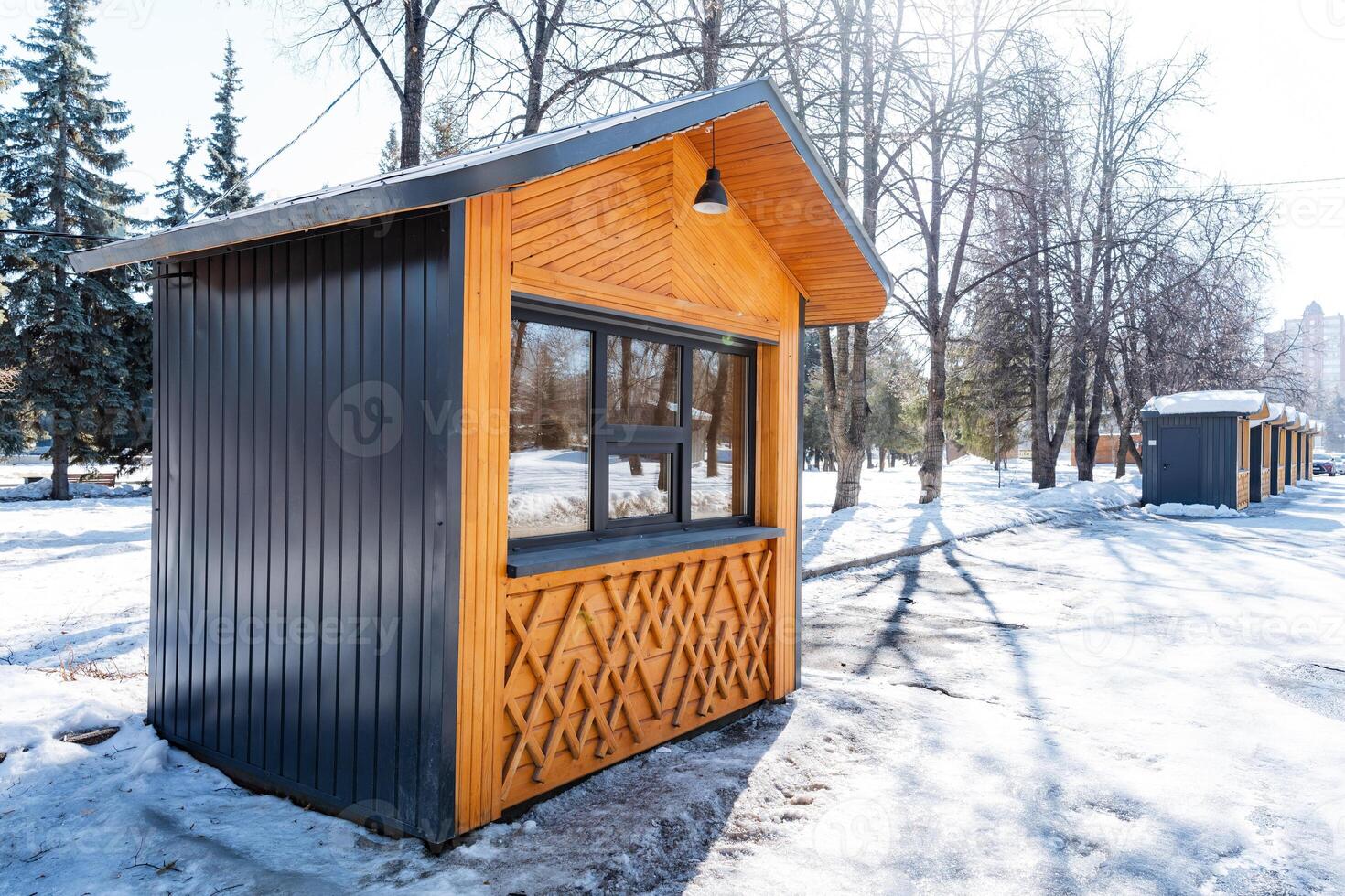 a small wooden hut is sitting in the snow in a park photo