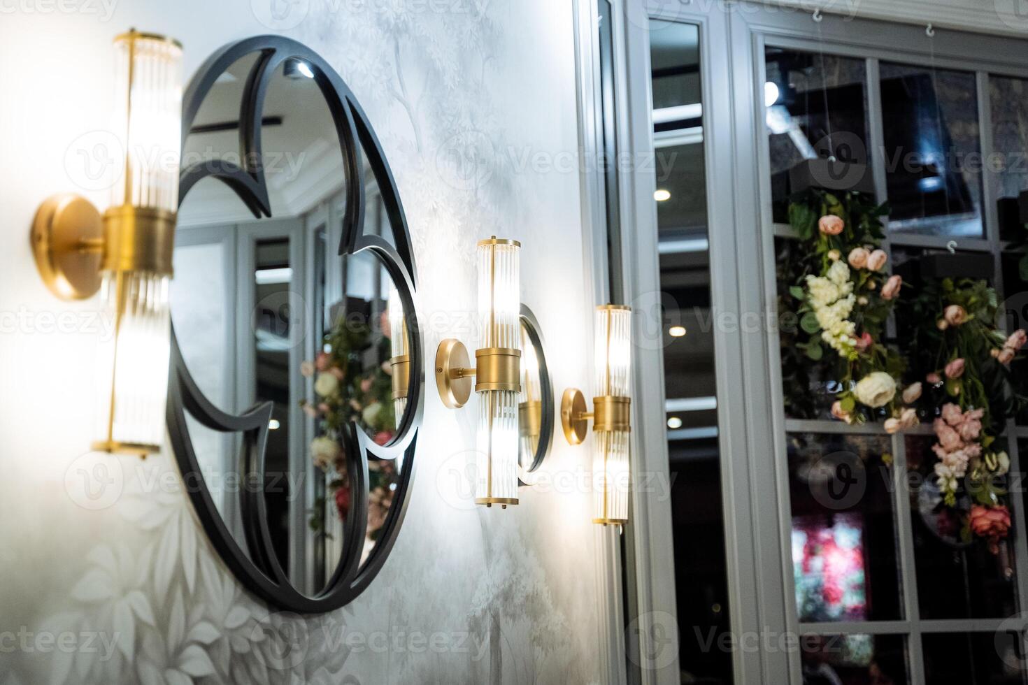A round mirror is a fixture on a wall beside a window photo