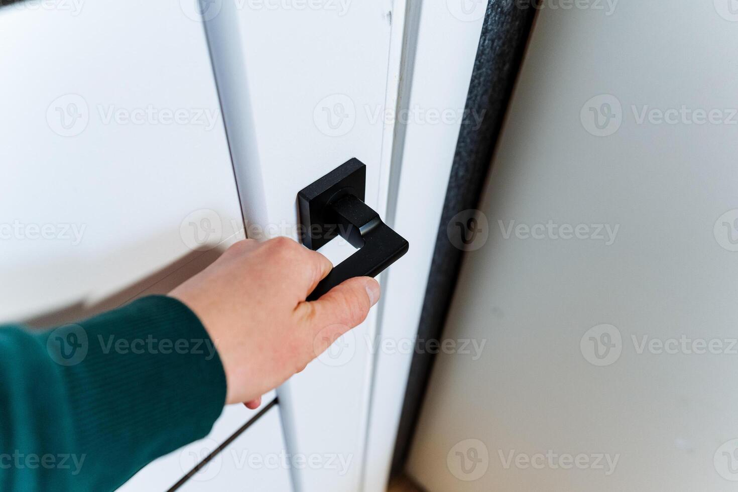 Using a sleek black handle, the person opens the door with a smooth gesture photo