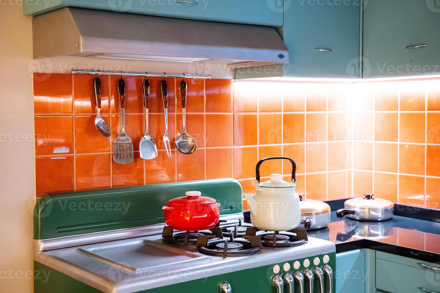 Kitchen with green gas stove and orange tile countertop photo