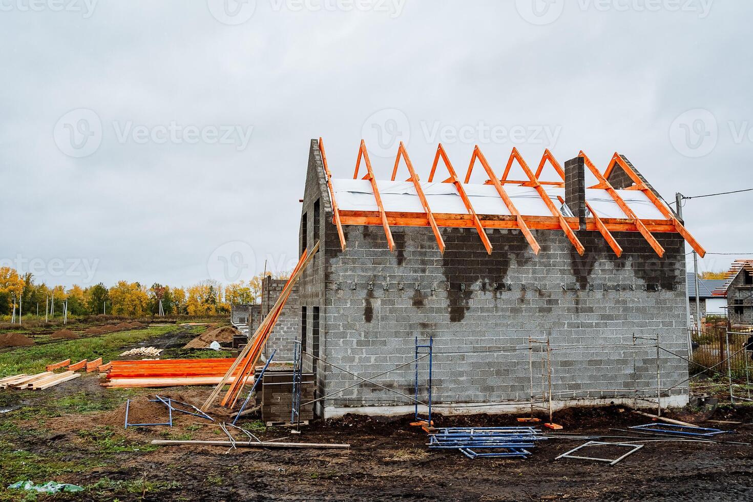 A house is currently being constructed using wooden beams for the roof photo