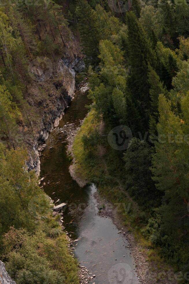 A landscape with water surrounded by trees in a canyon viewed from above photo