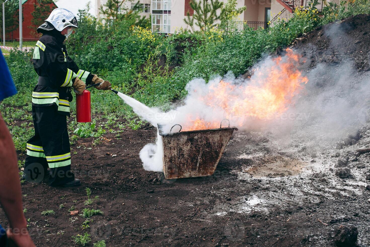 A firefighter is extinguishing a blazing fire with a fire extinguisher photo
