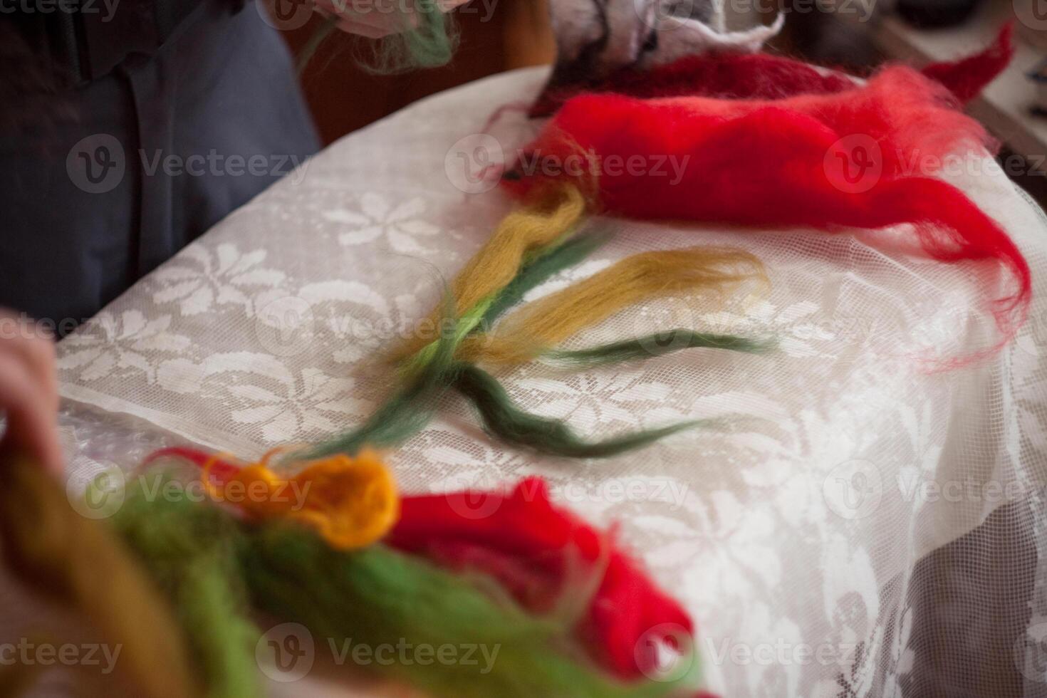Person creating wool flower on table as art project photo