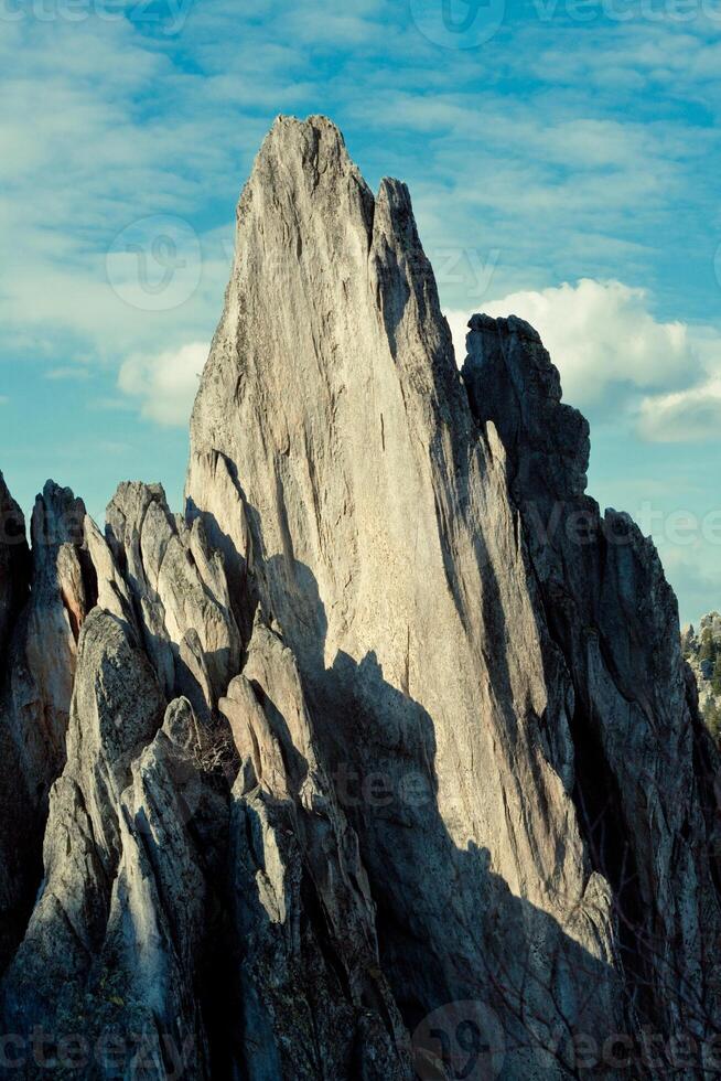 a large rocky mountain with a blue sky in the background photo