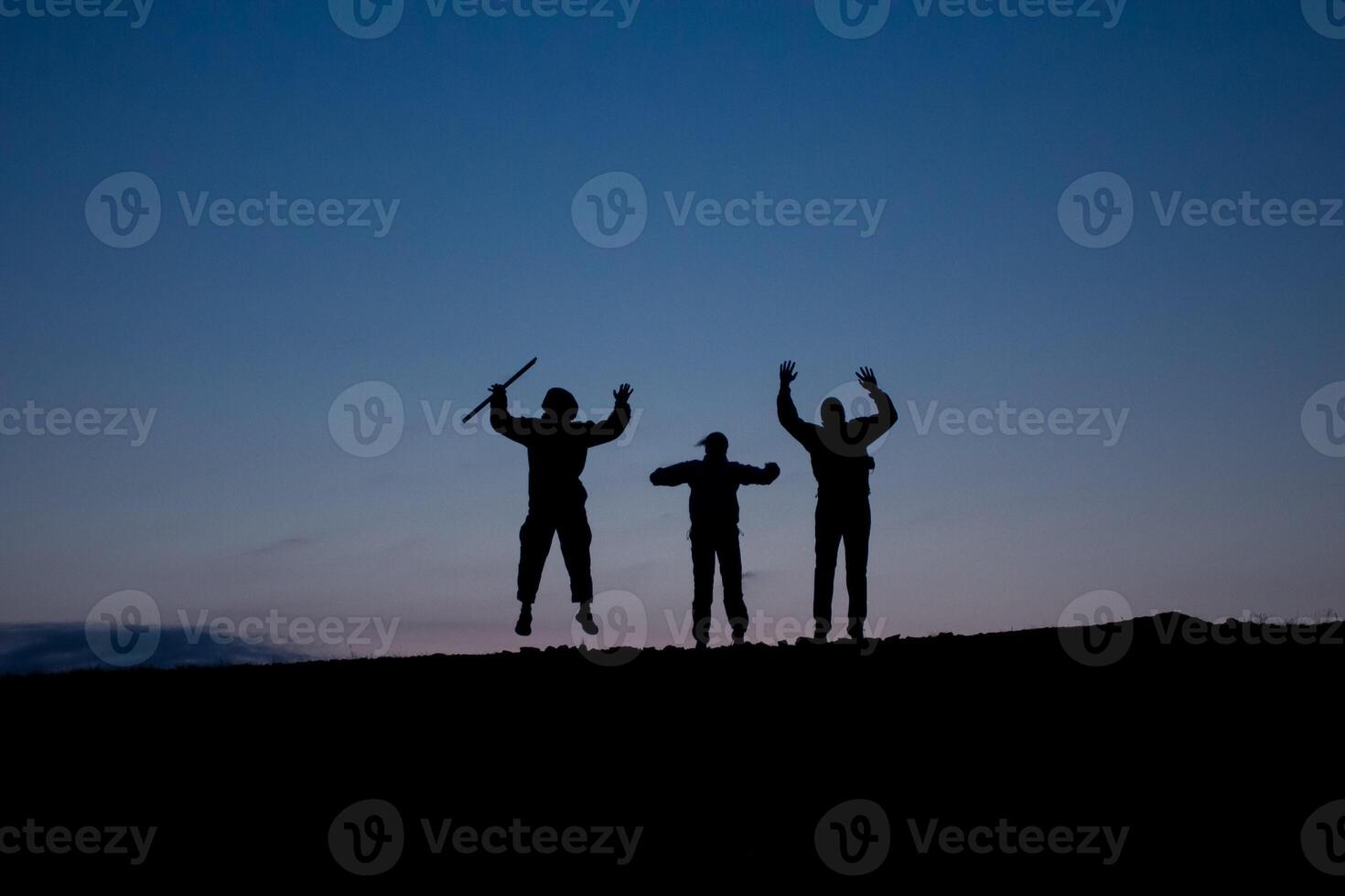 three people are jumping in the air with their arms in the air photo
