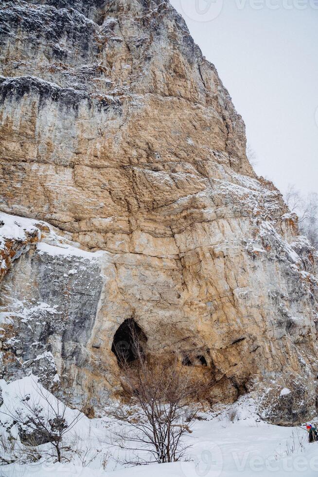 Kalimuskan Rock and Salavat Cave in Bashkiria, entrance to the cave in the mountain, winter landscape, nature of Russia. photo
