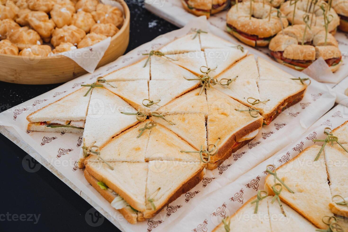 Delicious sausage sandwiches, triangular slices of bread, ham sandwiches, an appetizer on the table. photo