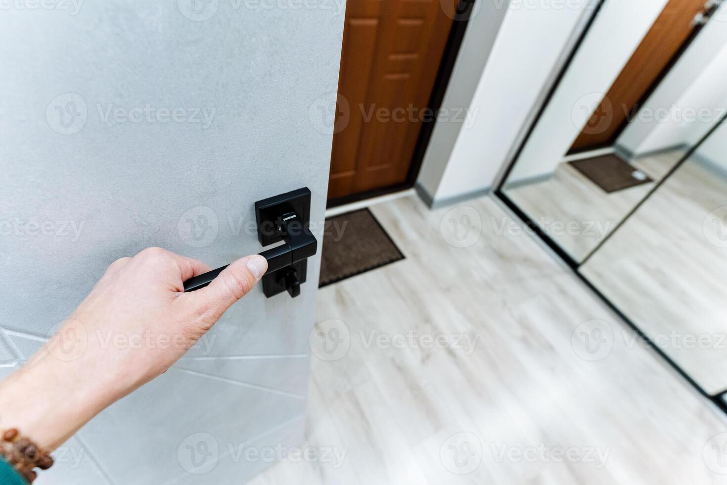 Hand holding door handle open door, front door to house, hallway, photo