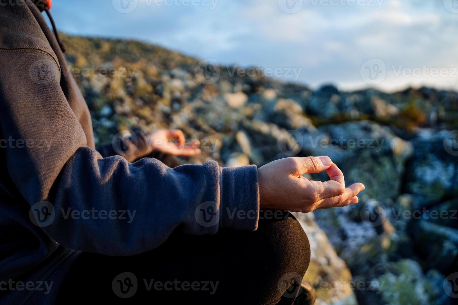 Chinmudra on the hand, fingers folded in mudra, meditation in the mountains, a fragment of a body part, the hand rests on the knee, yoga in practice. photo