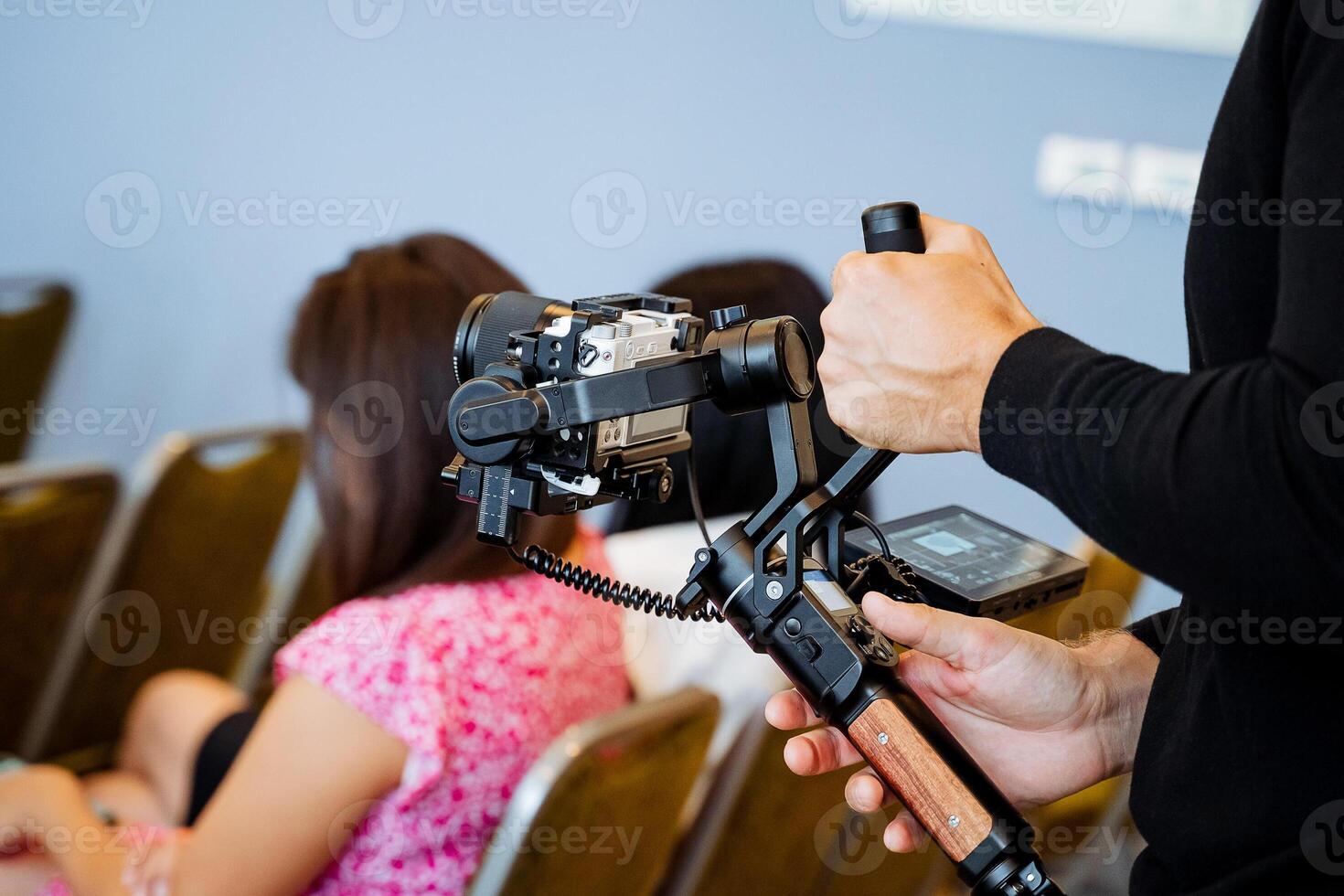 Shooting process from hand to camera, a person shoots an event holding steadicam in his hands, a device that balances the camera, an image stabilizer. photo