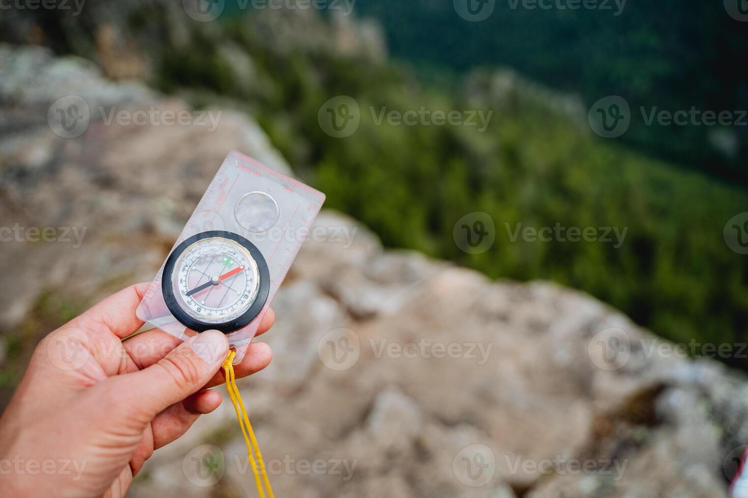 A person holds in his hand a close-up compass, orienteering on the ground. The man got lost in the forest, the direction of the world. photo