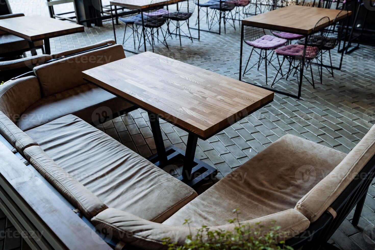 A cozy place for lunch, an outdoor cafe, an empty table, soft seats, sofas for relaxation, a restaurant in the city, an outdoor bar without people. photo