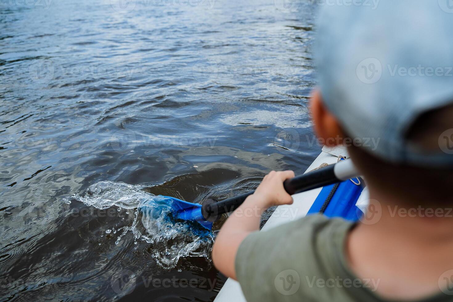A man's foot sticks out in the water, a paddle for kayaking, a man rafting a canoe on a mountain river, water sports, a summer vacation on the water. photo