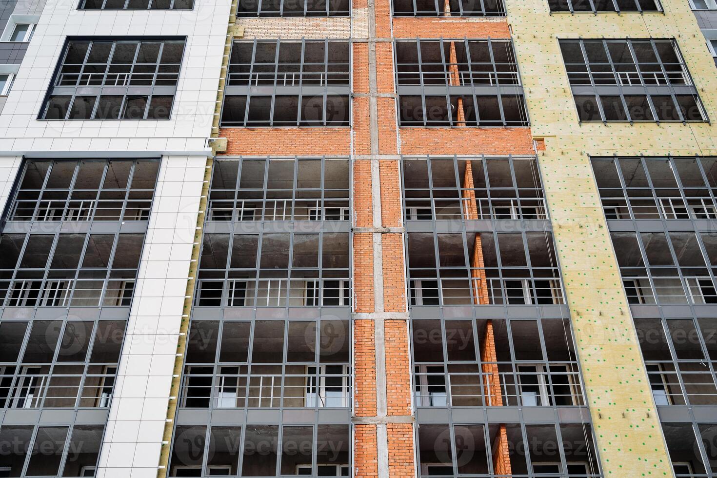 Insulation of the facade of the residential building. Construction works, laying mineral wool on the walls. Protection of the walls of the building. Thermal insulation from the outside. photo