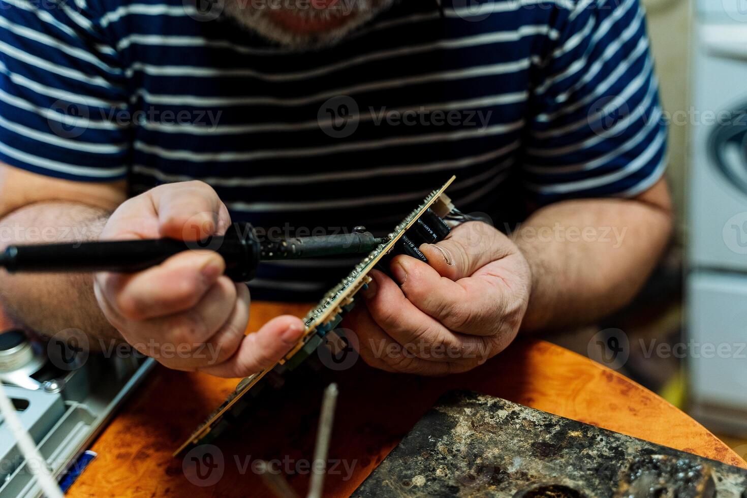 Hands solder electronics chip. Finely handmade. Soldering iron in hand. photo