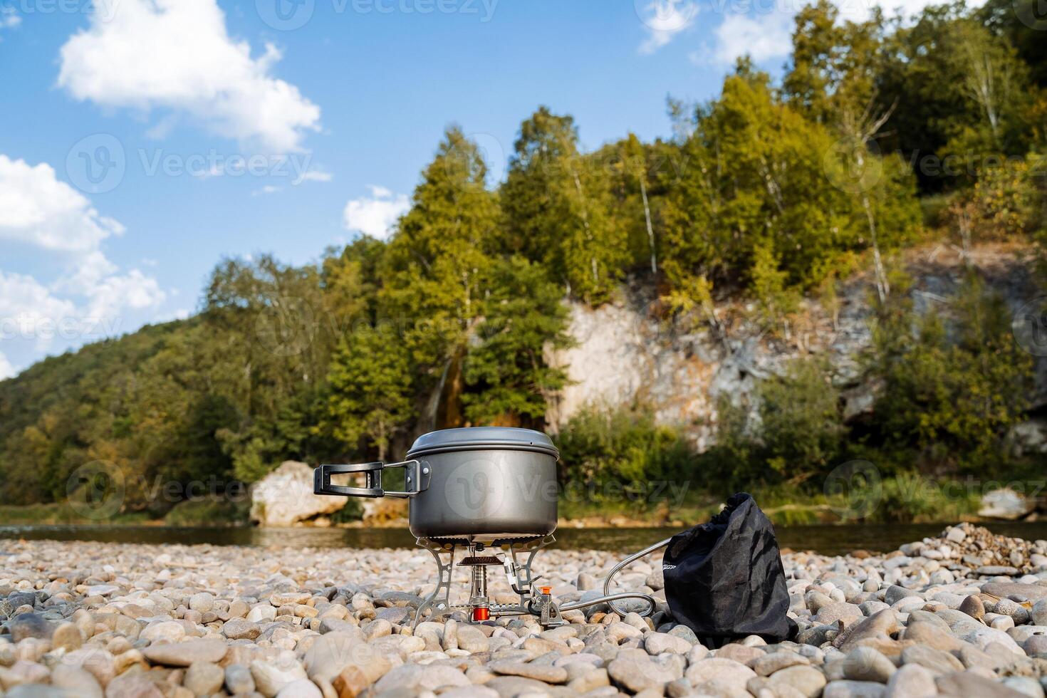 A camping stove and a bag on the rocks photo