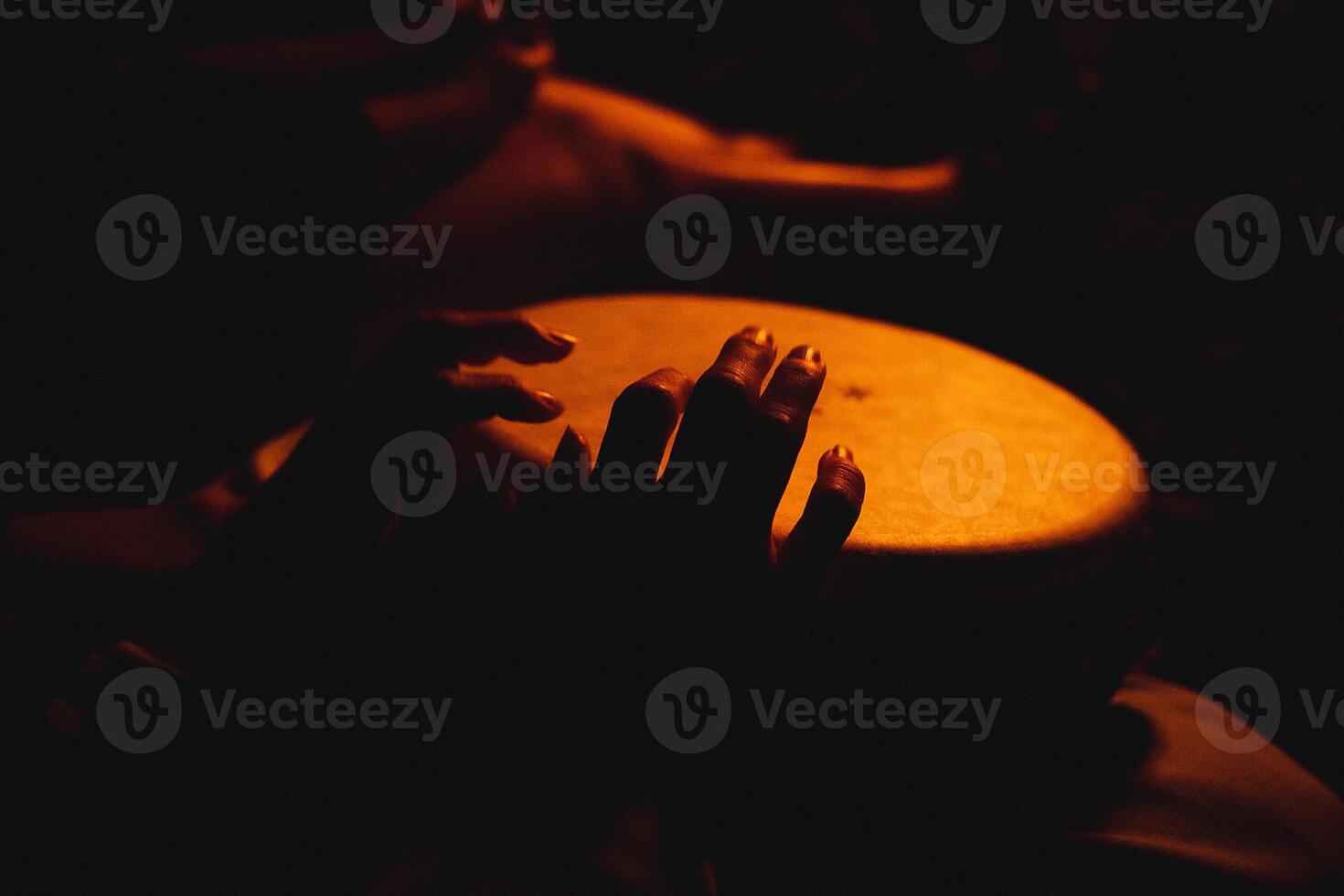 A close shot of the hands of a man playing a melody on ethnic drums photo