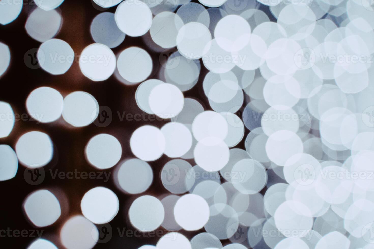 White blurry light from garlands on a dark background. Bright shot. photo