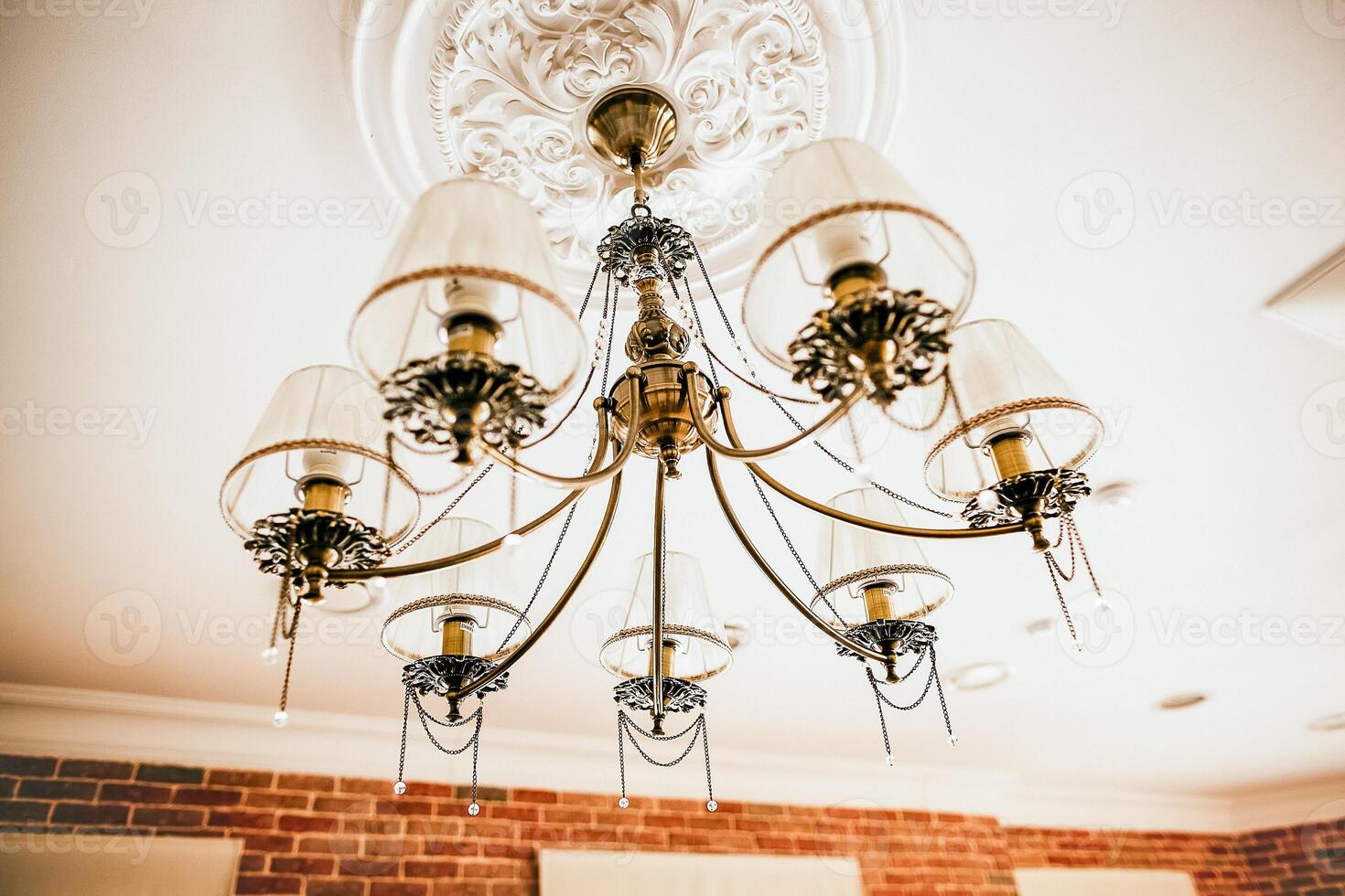 The chandelier hangs on the ceiling. Beautiful vintage lamp in the interior of the apartment. apartment design. lighting in the house. Boho style. Elegant fixture. photo
