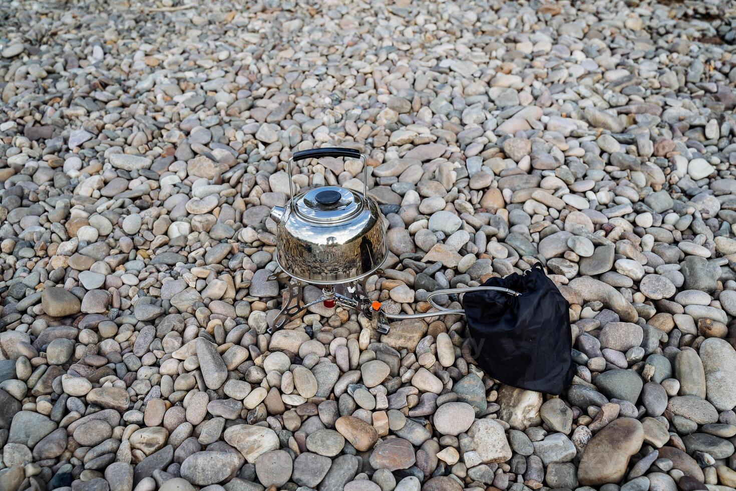 Cooking on a hike on the banks of the river. The concept of tourist cuisine. Tableware for tourists. Minimalism in travel. photo