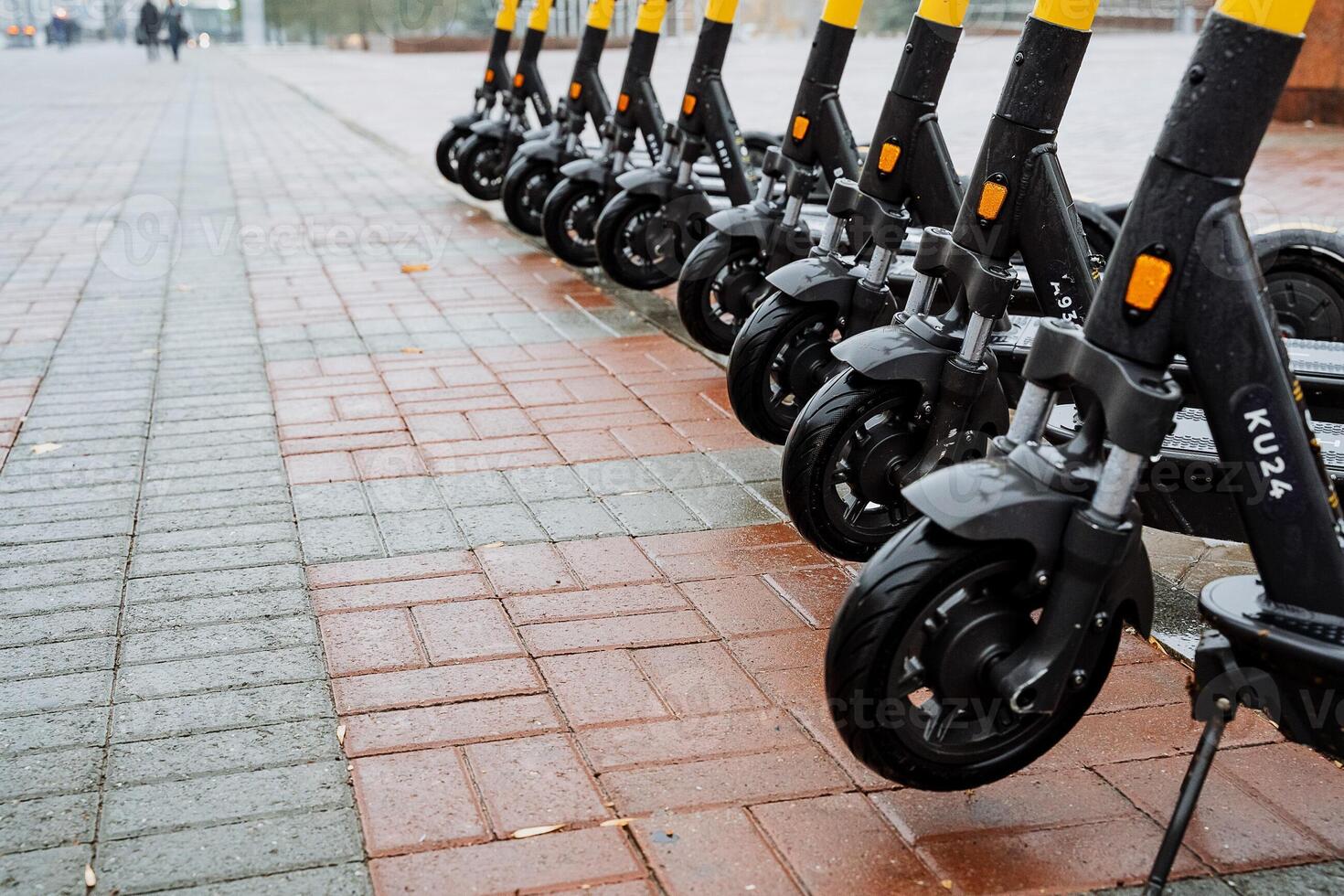 Parking of electric scooters on the street. The wheels of the scooter are in a row. The concept of eclogical transport. Black color of scooter photo