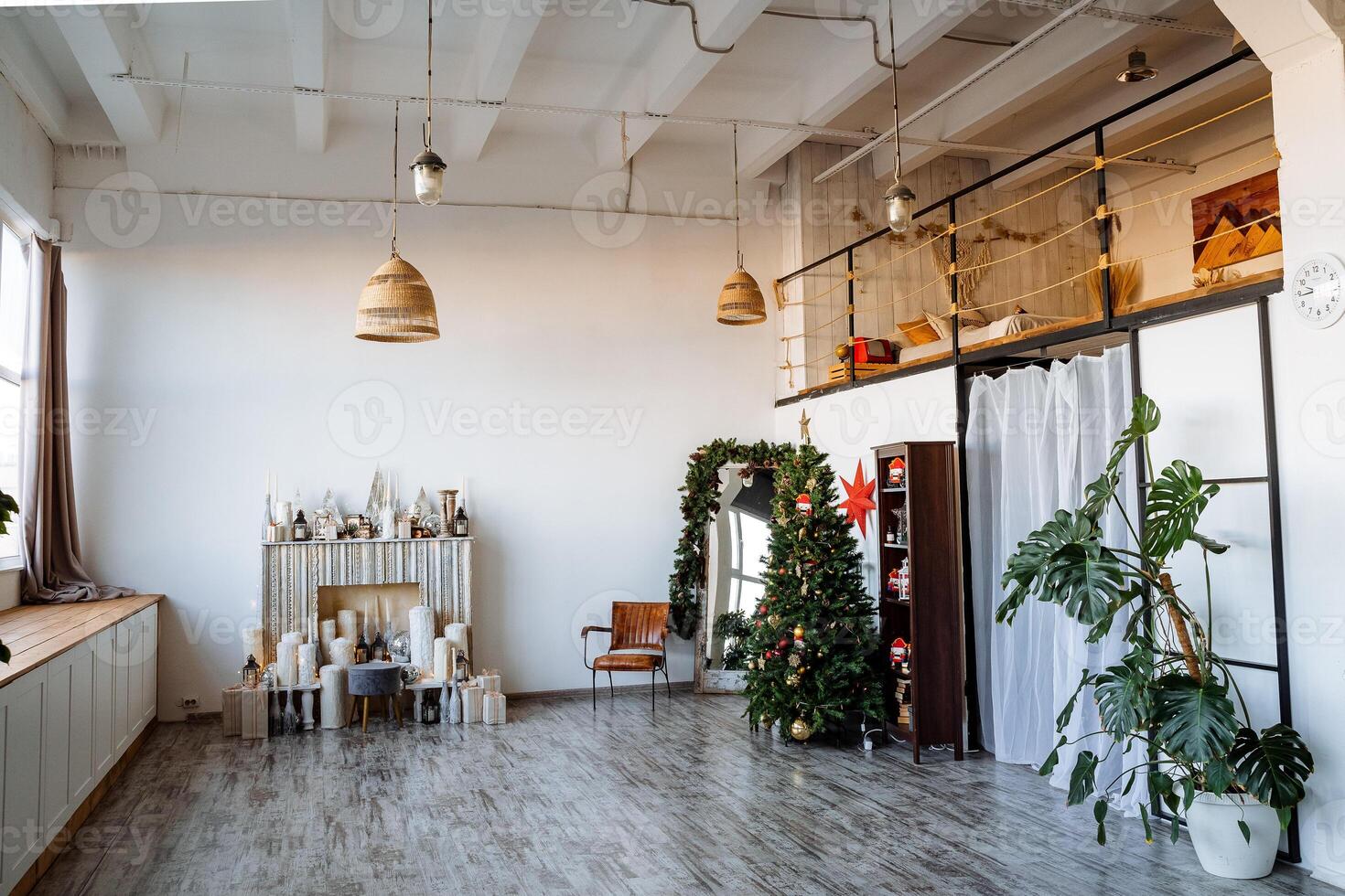 Interior shot. Two-storey room with large panoramic window, fireplace, decorated Christmas tree, preparations for the new year Modern apartment. photo