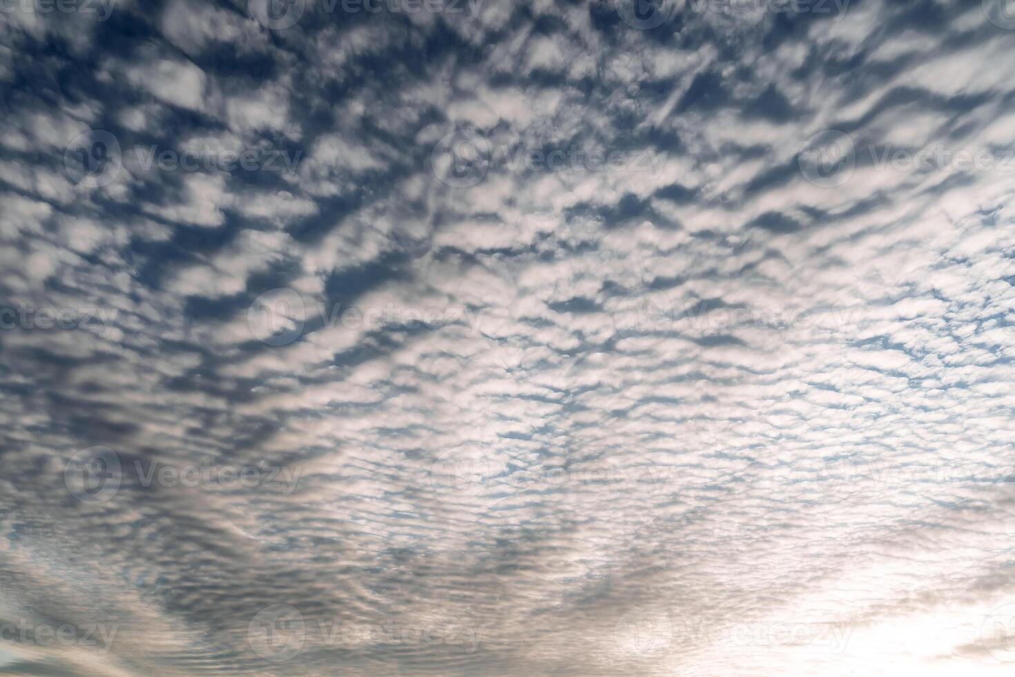 cimbling clouds in the blue sky. drawing of clouds in the sky. sunset evening photo