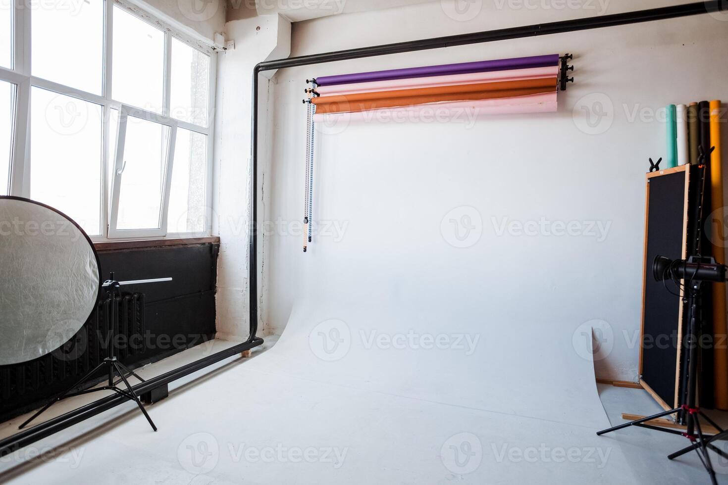photo Studio interior, white cyclorama, colored backgrounds, lighting device on a tripod