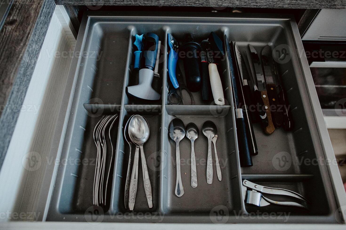 A set of Cutlery in a drawer. Correct placement of knives, forks and spoons in the drawer. Order in the kitchen. The concept of order in the house. photo